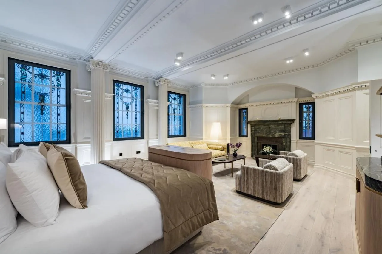 a bedroom with a bed and a living room at Stock Exchange Hotel, Manchester, Autograph Collection in Manchester