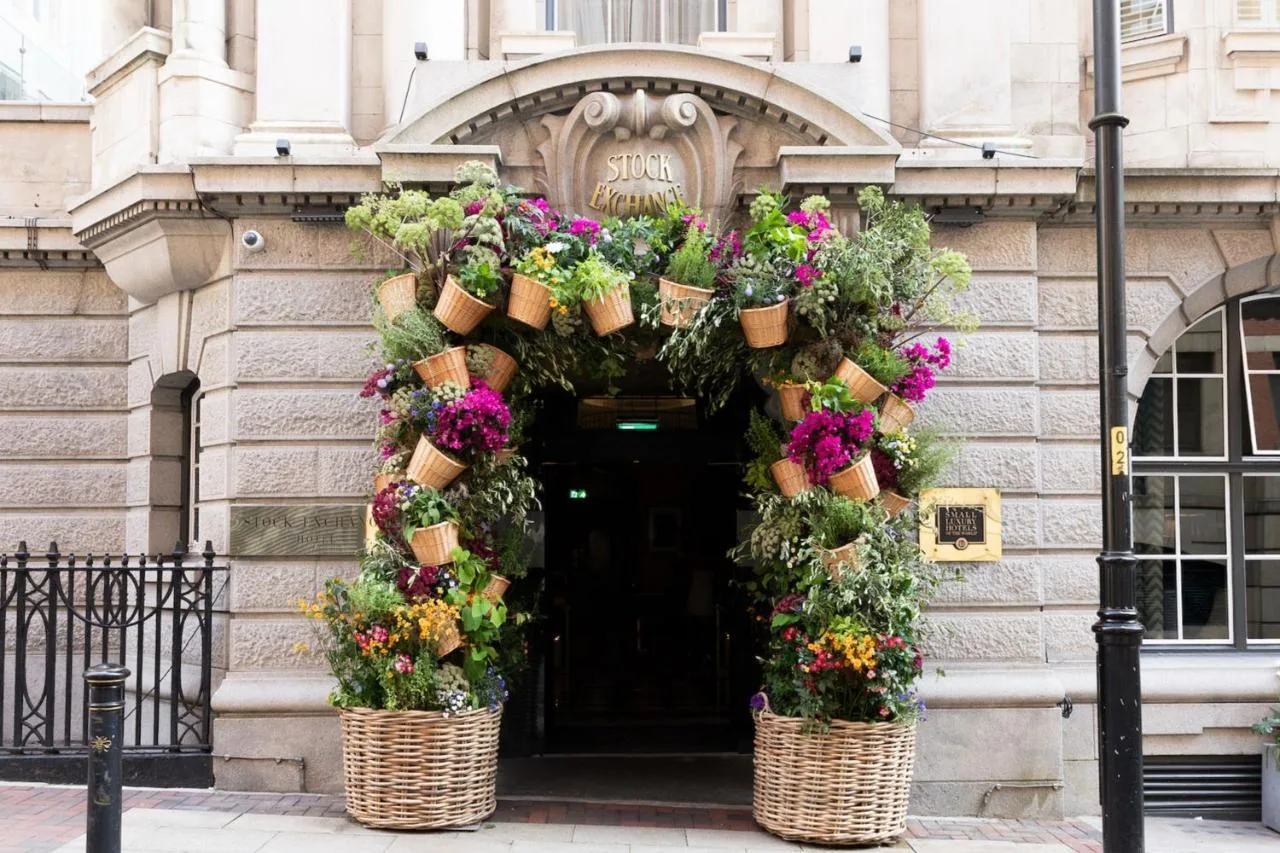 two baskets filled with flowers in front of a building at Stock Exchange Hotel, Manchester, Autograph Collection in Manchester