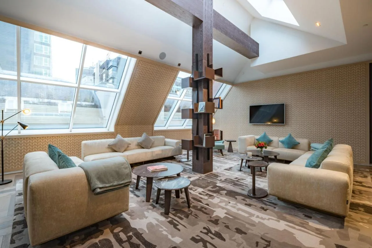 a living room with couches and a tv at Stock Exchange Hotel, Manchester, Autograph Collection in Manchester